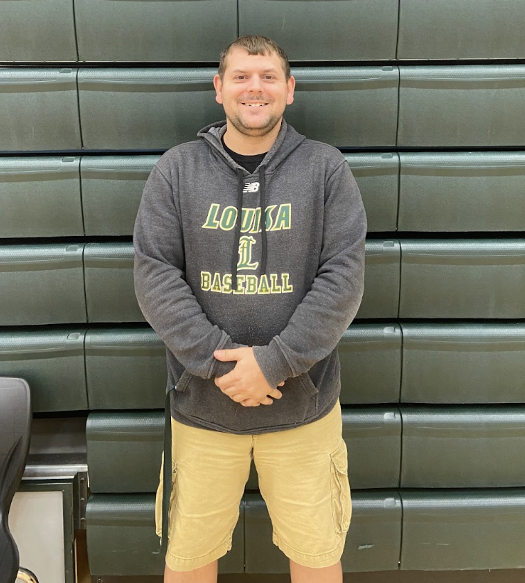 Physical Education and Drivers Ed Teacher and coach Derek Hall stands proudly in the gymnasium.